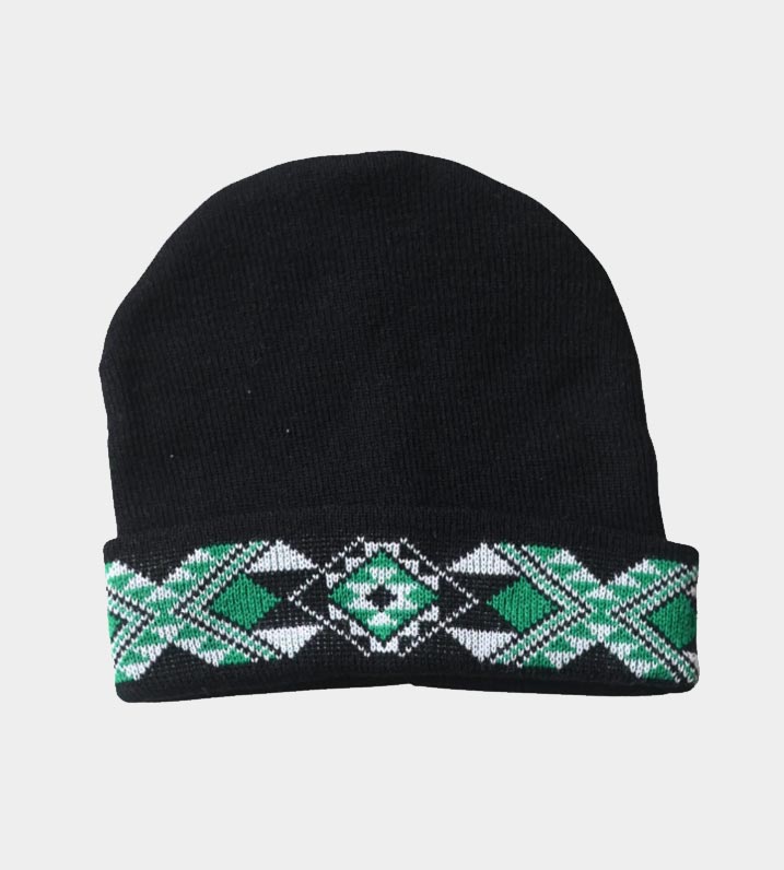 Black knitted beanie with green and white Māori Tāniko design stitched into the turned up band.